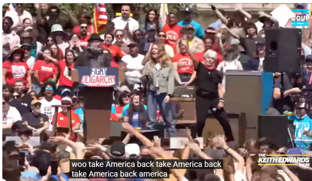 still from video: Neil Young, Maggie Rogers and Joan  Baez, on stage shouting 'Take America Back"