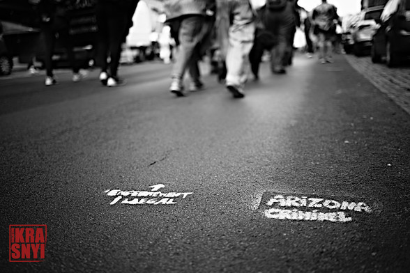 Les manifestants marchent, au sol deux tags "ENFERMEMENT ILLEGAL" ET "ARIZONA CRIMINEL"