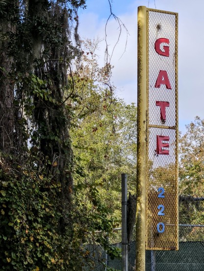 Old, rusty signage next to a city park reads: GATE 220