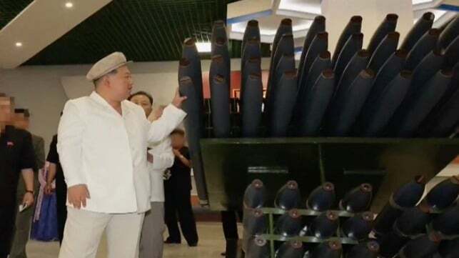 North Korean dictator Kim Jong Un examines rockets at a factory, Apr 2025 (KCNA via OSC)
