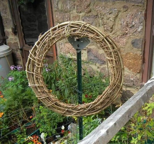 One large wreath made of bare weathered wisteria and trumpet vines. Simple round-and-round construction with a single spiral wrap to bind it all together around the outside. 