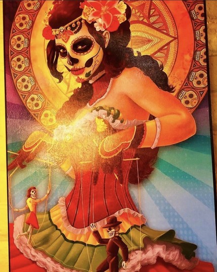 Woman adorned in day of the dead make up pulling the strings of the living puppets attached to the strings 